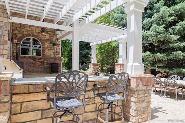 view of patio with exterior kitchen, outdoor dining space, outdoor wet bar, and a pergola