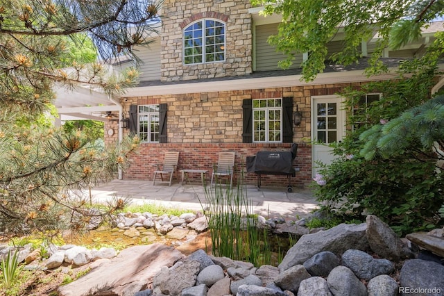 exterior space featuring brick siding and a patio area