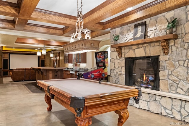 game room featuring finished concrete floors, beamed ceiling, and a stone fireplace