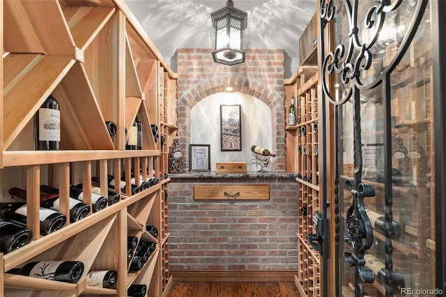 wine cellar featuring brick wall and wood finished floors