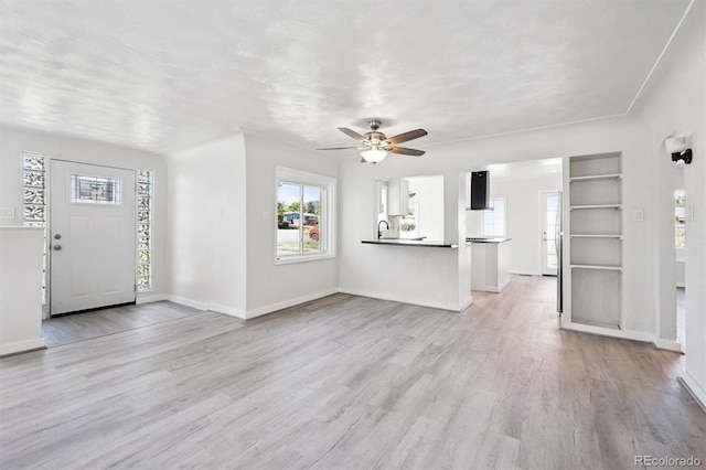 16707 W 10th Ave, Golden, CO 80401 - unfurnished living room with healthy amount of natural light, a ceiling fan, and light wood-style floors