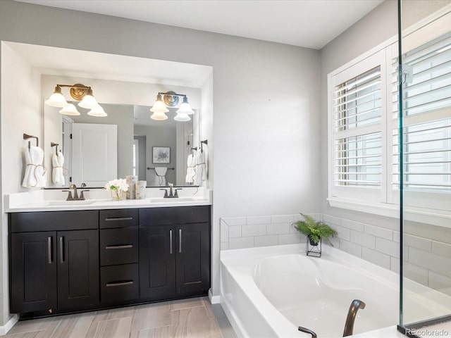 bathroom featuring vanity and a relaxing tiled tub