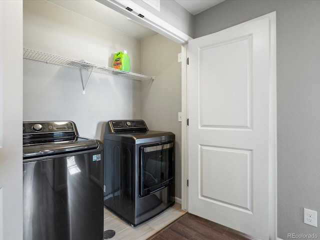 clothes washing area featuring hardwood / wood-style floors and washing machine and clothes dryer