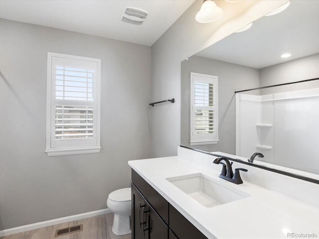 bathroom with vanity, wood-type flooring, a shower, and toilet