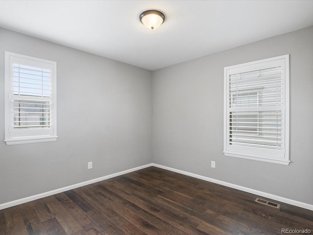 empty room with dark hardwood / wood-style flooring