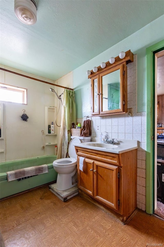 full bathroom featuring shower / bath combo, tile walls, vanity, a textured ceiling, and toilet