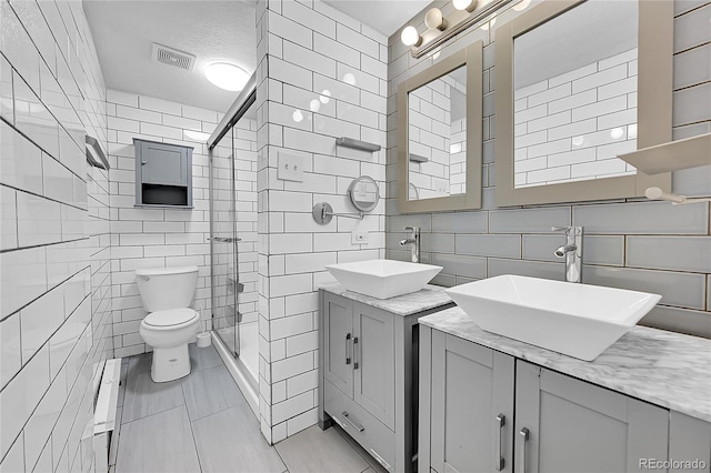 full bathroom featuring two vanities, visible vents, a sink, and toilet