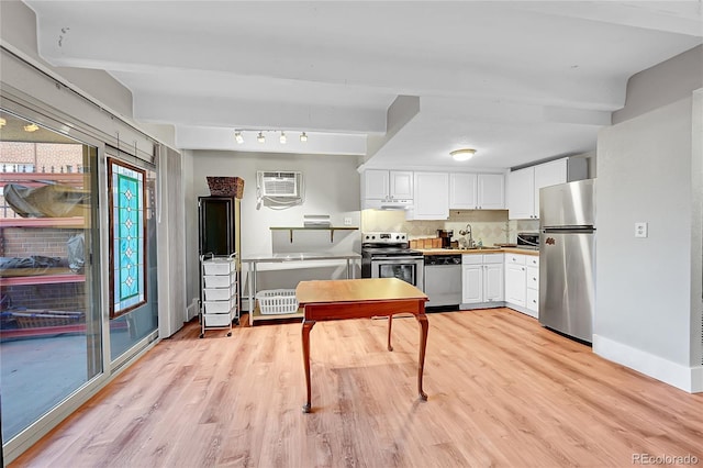 kitchen with sink, white cabinetry, tasteful backsplash, a wall unit AC, and stainless steel appliances