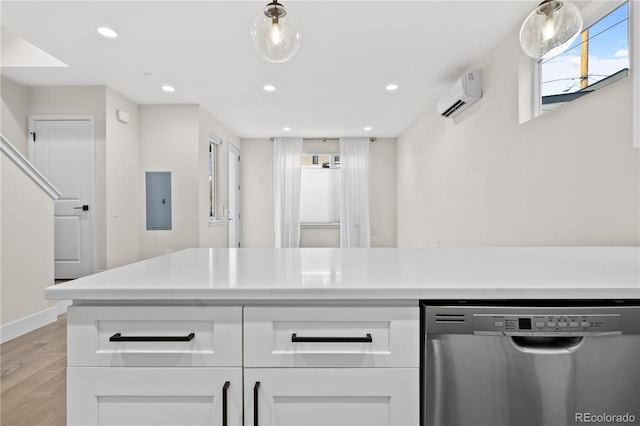 kitchen featuring white cabinetry, stainless steel dishwasher, a wall mounted AC, and light hardwood / wood-style floors