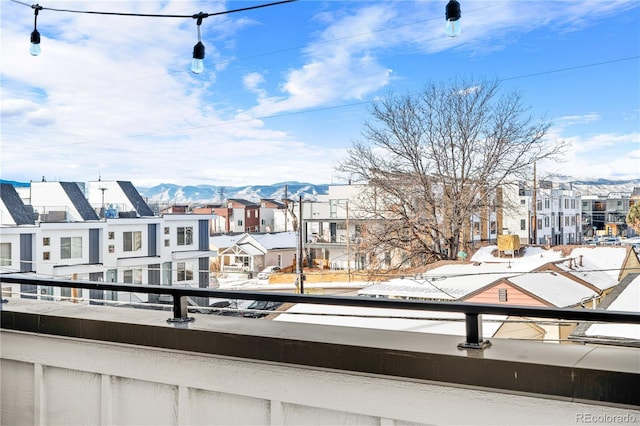 snow covered back of property with a mountain view