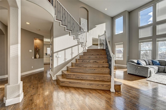 stairs with a high ceiling and hardwood / wood-style flooring