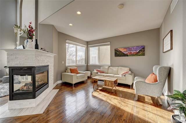 living room with a multi sided fireplace and hardwood / wood-style flooring