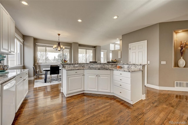 kitchen featuring light stone countertops, white cabinets, dishwasher, dark hardwood / wood-style flooring, and a notable chandelier