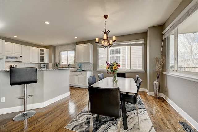 dining space featuring an inviting chandelier and light hardwood / wood-style floors