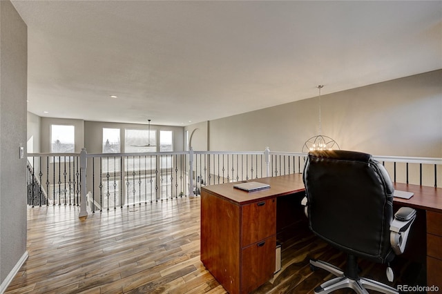 office space featuring wood-type flooring and a chandelier