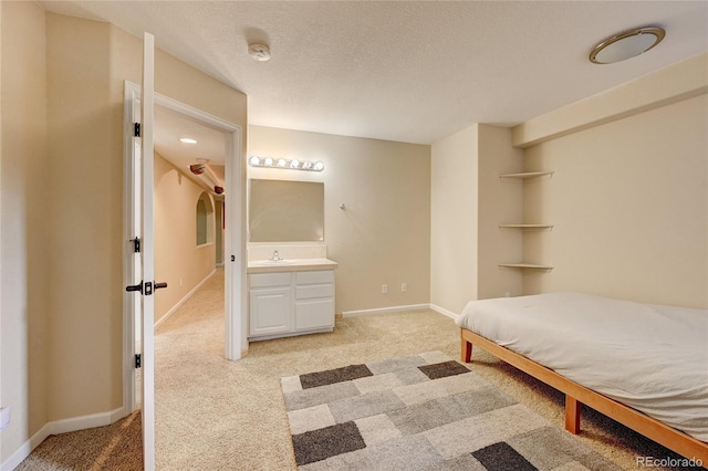 unfurnished bedroom featuring light colored carpet, ensuite bathroom, and sink