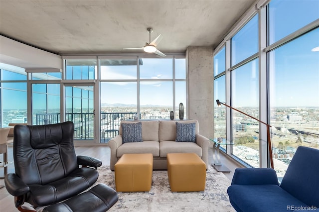 sunroom / solarium featuring a view of city and ceiling fan