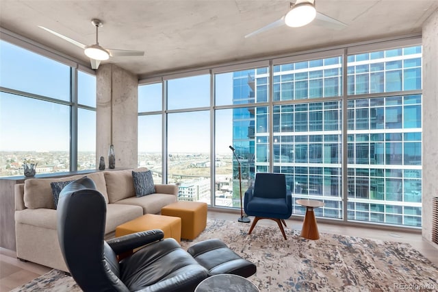 living room featuring expansive windows, a ceiling fan, and wood finished floors