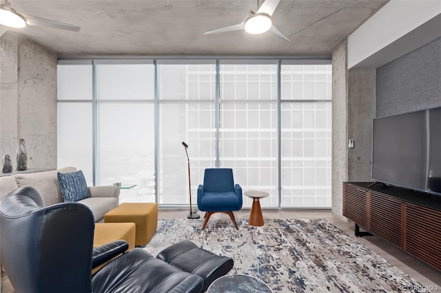 living area featuring a wall of windows and ceiling fan