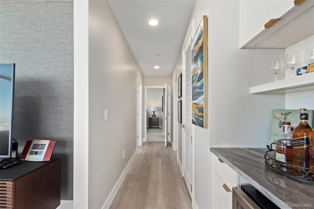 hallway with light wood-type flooring, baseboards, and recessed lighting