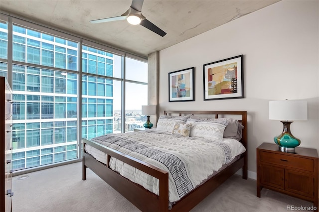 carpeted bedroom featuring a wall of windows and a ceiling fan