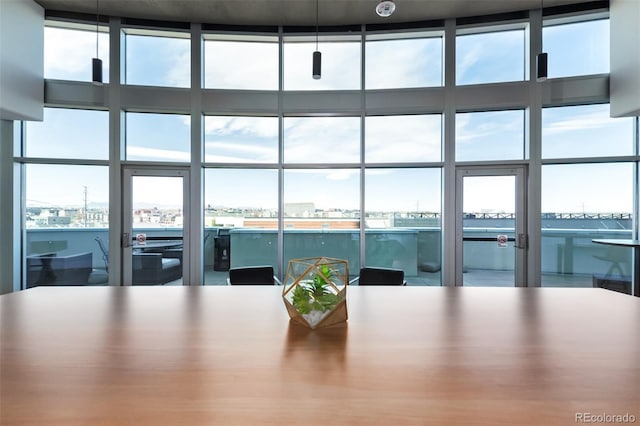 unfurnished dining area with plenty of natural light, a view of city, and a wall of windows