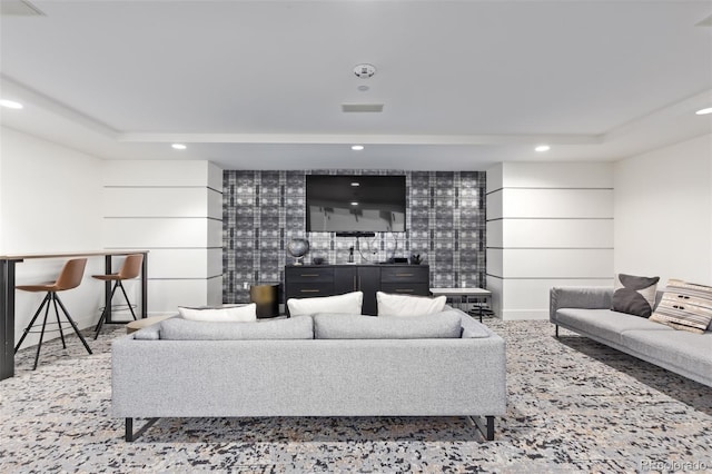 living room featuring baseboards, a tray ceiling, and recessed lighting