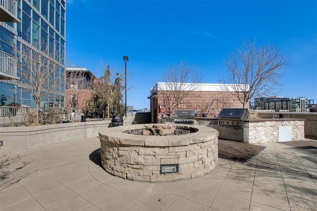 view of patio featuring an outdoor fire pit, a city view, a grill, and area for grilling