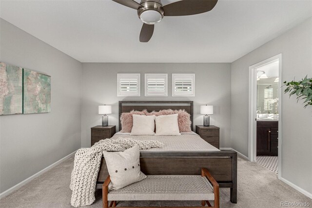 bedroom with ensuite bath, light colored carpet, and ceiling fan