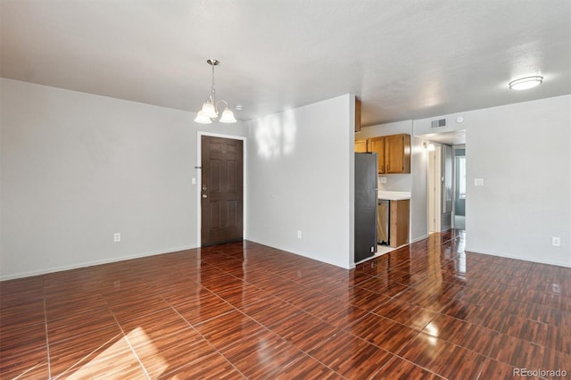 unfurnished living room featuring an inviting chandelier