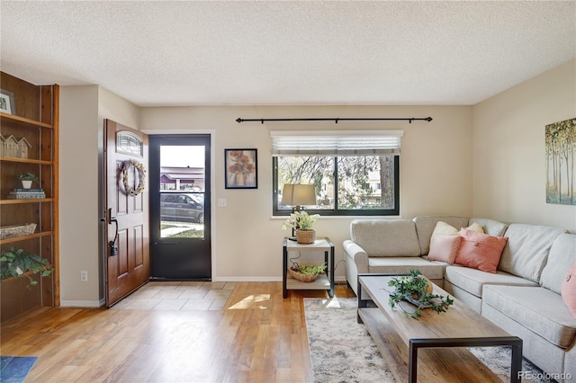 living room featuring light hardwood / wood-style floors and a textured ceiling