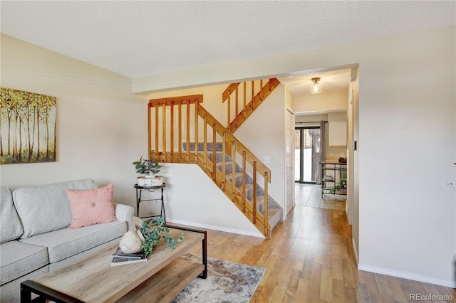 living room with light hardwood / wood-style floors and a textured ceiling