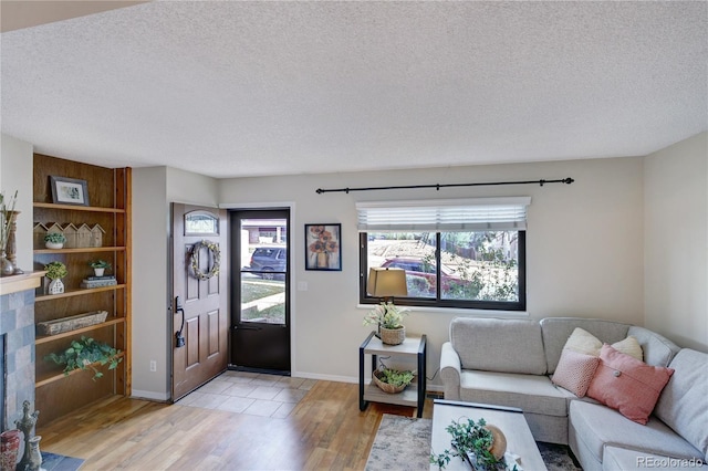 living room featuring light wood-type flooring and a textured ceiling