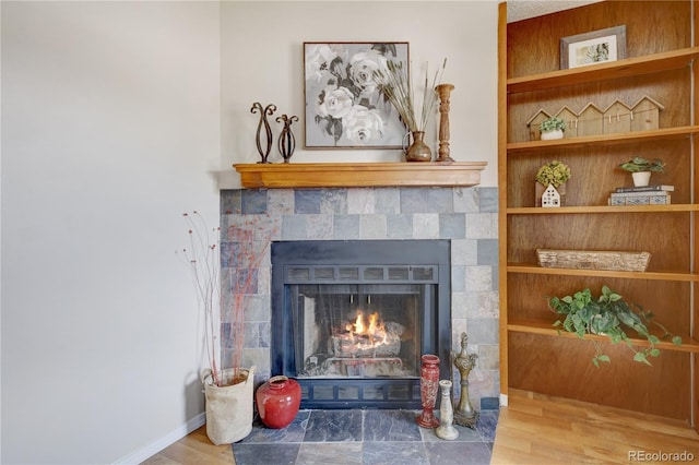 details featuring hardwood / wood-style floors and a tile fireplace