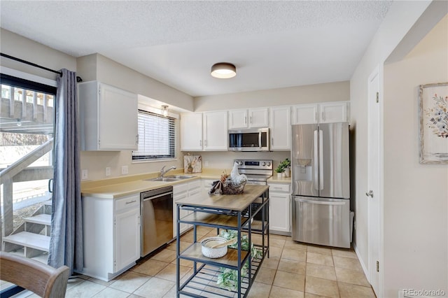 kitchen featuring white cabinets, light tile patterned floors, and appliances with stainless steel finishes