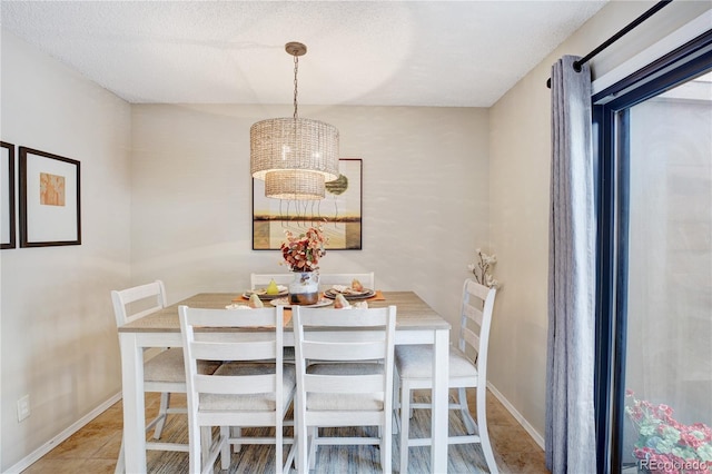 dining area with a textured ceiling and a notable chandelier