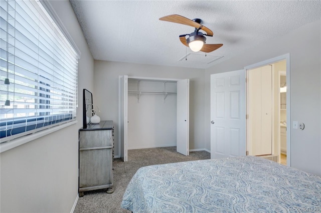 bedroom featuring ceiling fan, a closet, light colored carpet, and a textured ceiling