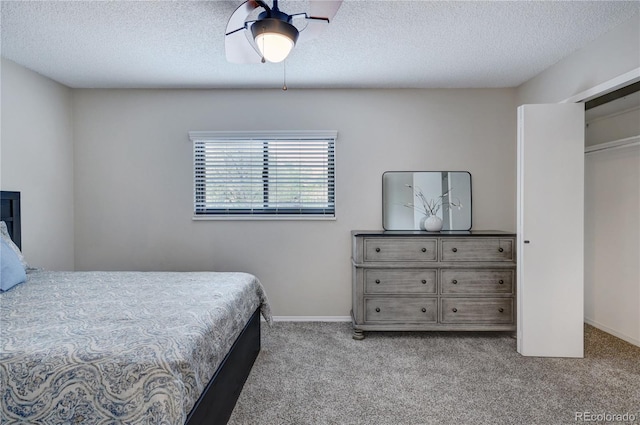 bedroom with ceiling fan, a closet, light carpet, and a textured ceiling