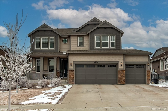 craftsman-style home with an attached garage, concrete driveway, a porch, and stone siding