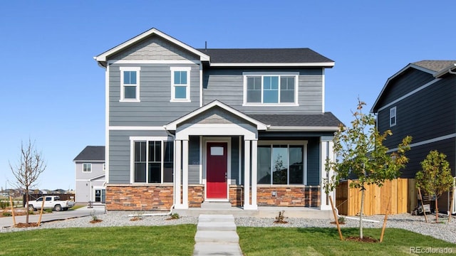 craftsman-style house with stone siding and a shingled roof