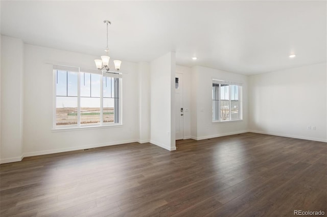 empty room with a chandelier, dark wood-style floors, baseboards, and recessed lighting