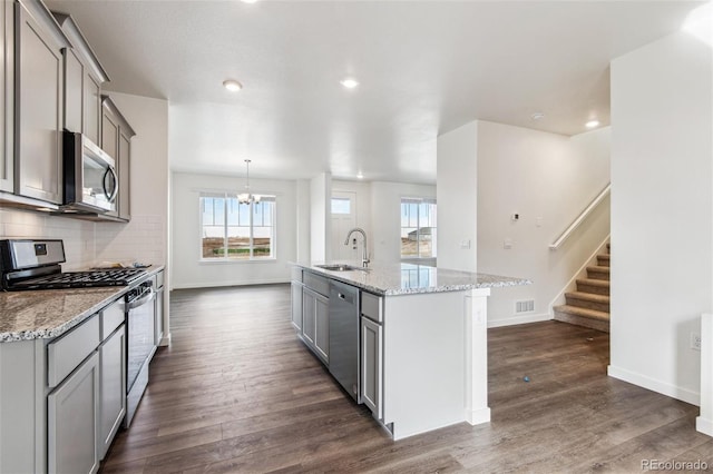 kitchen featuring appliances with stainless steel finishes, gray cabinets, a sink, baseboards, and recessed lighting