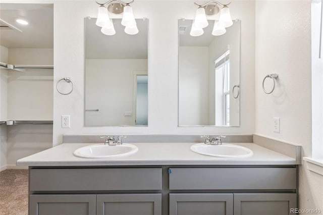 full bathroom featuring double vanity and a chandelier