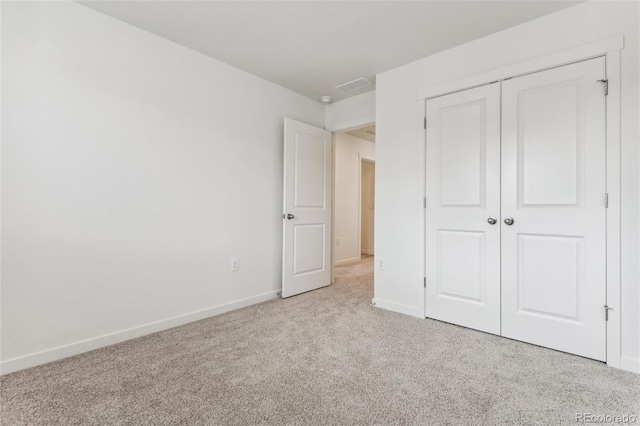 unfurnished bedroom featuring carpet, a closet, and baseboards