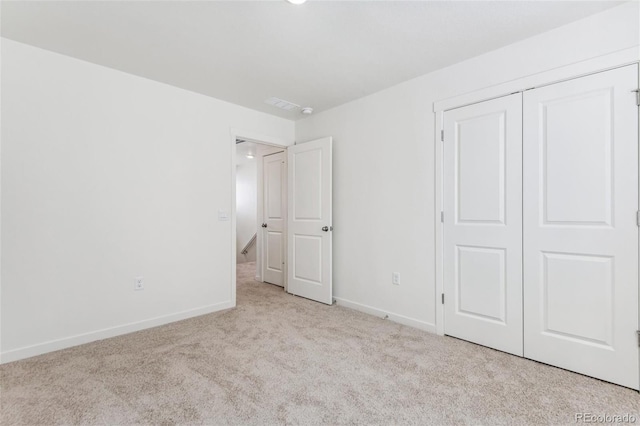 unfurnished bedroom featuring carpet flooring, baseboards, and a closet