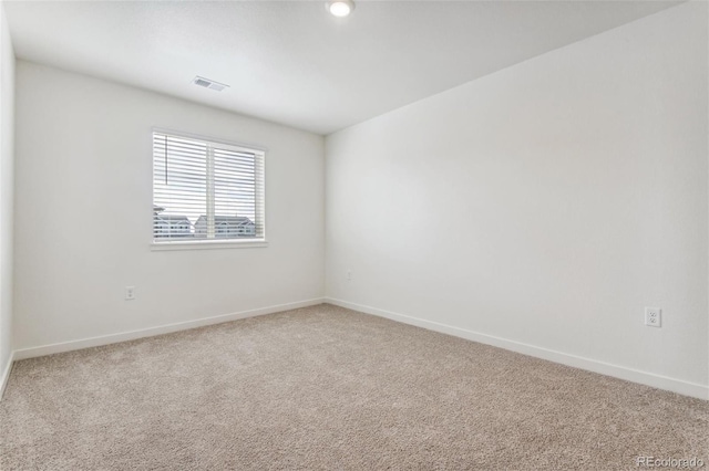 spare room with light carpet and baseboards