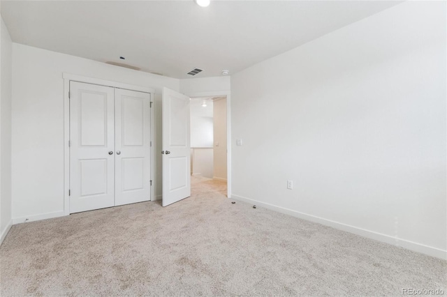 unfurnished bedroom featuring carpet, baseboards, and a closet