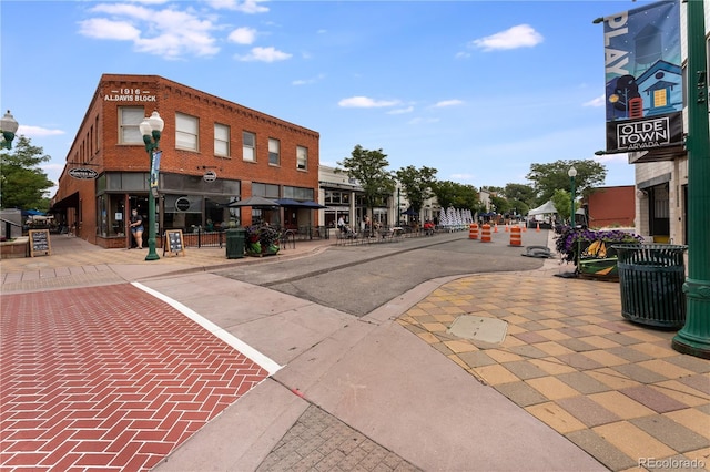 8675 W 60th Ave, Arvada, CO 80004 - view of asphalt road featuring street lights, sidewalks, and curbs