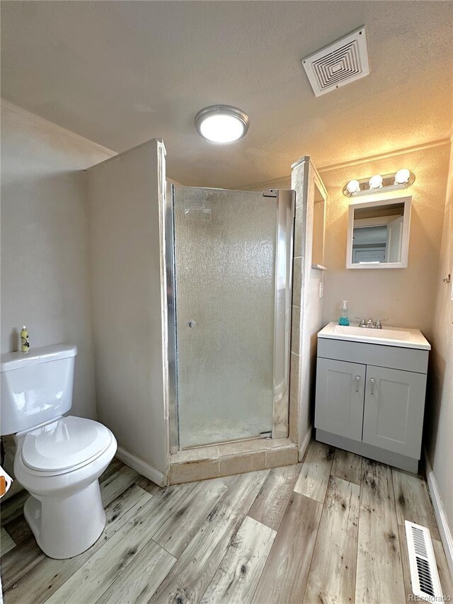 672 4th St, Limon, CO 80828 - bathroom with a stall shower, toilet, wood finished floors, and visible vents