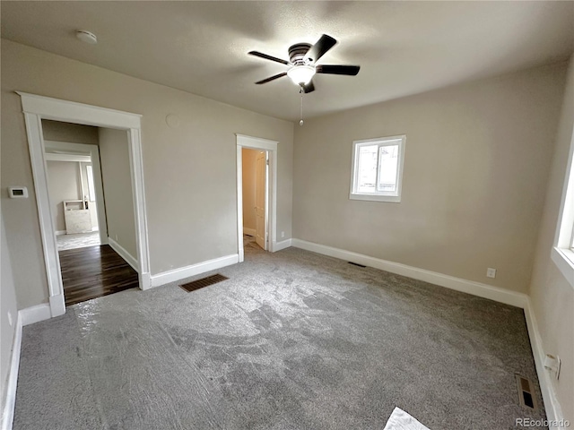 unfurnished bedroom with carpet floors, baseboards, and visible vents